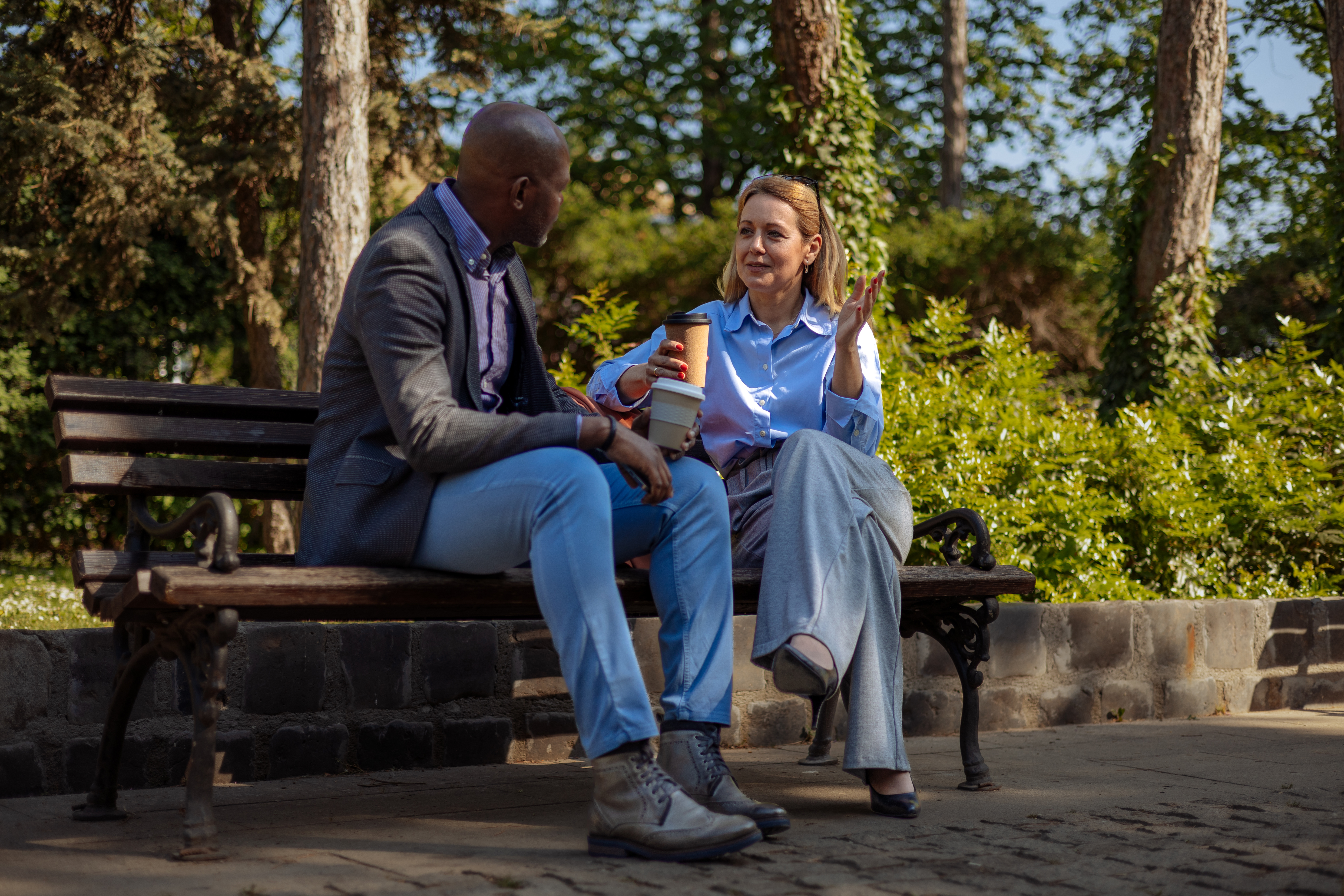 Two individuals talking on a bench